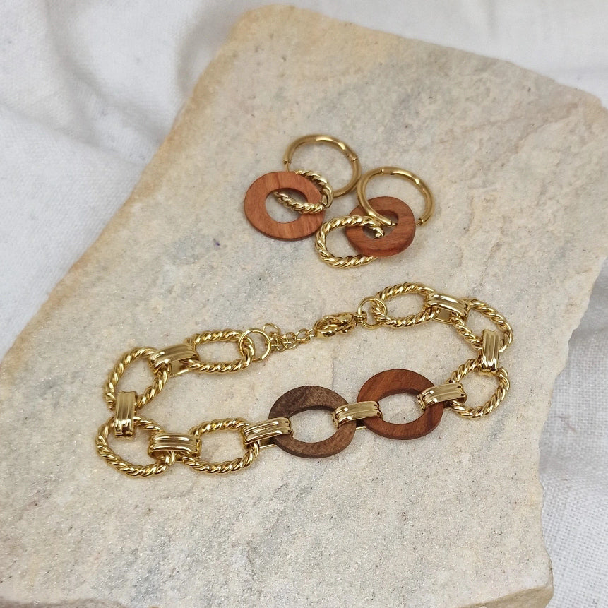 Handgefertigtes Schmuckset ‚Yara‘ aus Armkette und Kreolen aus Zwetschkenholz und Nussholz mit goldfarbenen Edelstahlelementen, arrangiert auf Naturstein