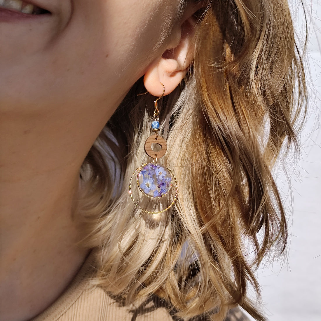 Frau trägt handgefertigte Ohrringe &