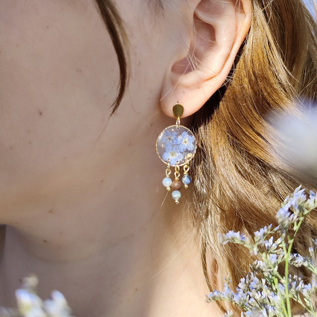 Ohrringe aus Resin mit echten Vergissmeinnicht-Blüten, Perlen und Nussholzkugel, goldfarbene Edelstahlstecker im Ohr