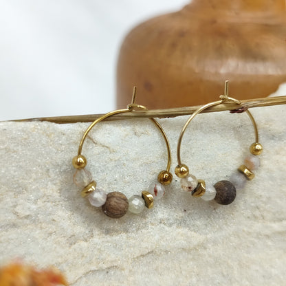 Paar Kreolen mit Mondstein und Nussperle nebeneinander auf hellem Untergrund, die Perlen hängen frei an der unteren Rundung der Kreole