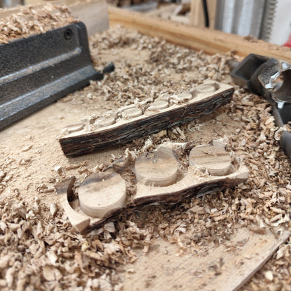 Werkstattaufnahme mit Holzspänen und bearbeiteten Holzscheiben aus Weinstockholz während der Schmuckherstellung