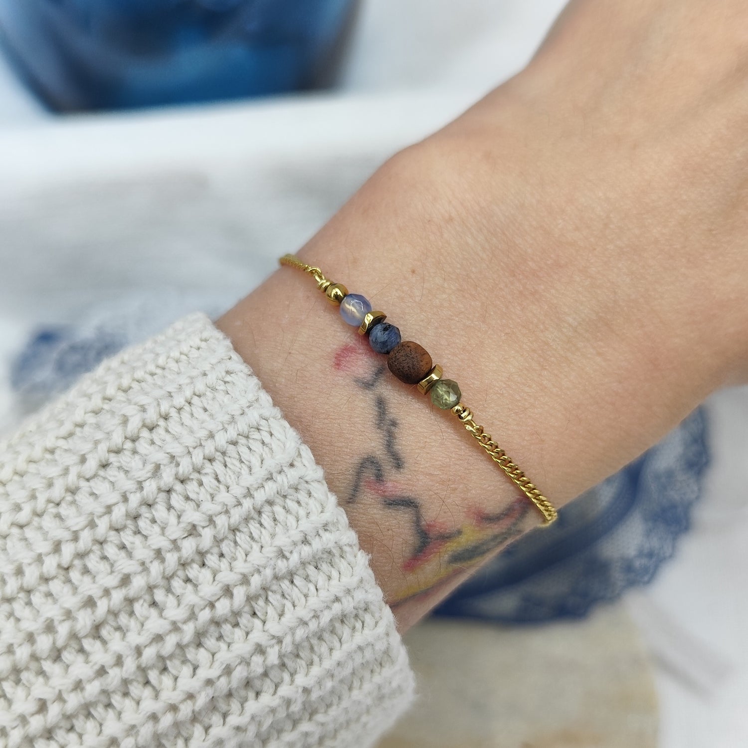 Fein gearbeitetes Armband mit Natursteinen, Hämatit-Zwischenteilen und Nussholzkugel, getragen am Handgelenk