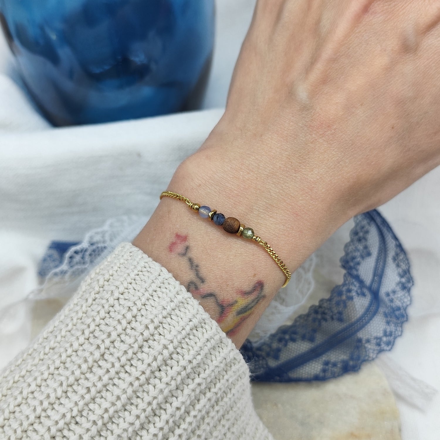 Fein gearbeitetes Armband mit Natursteinen, Hämatit-Zwischenteilen und Nussholzkugel, getragen am Handgelenk