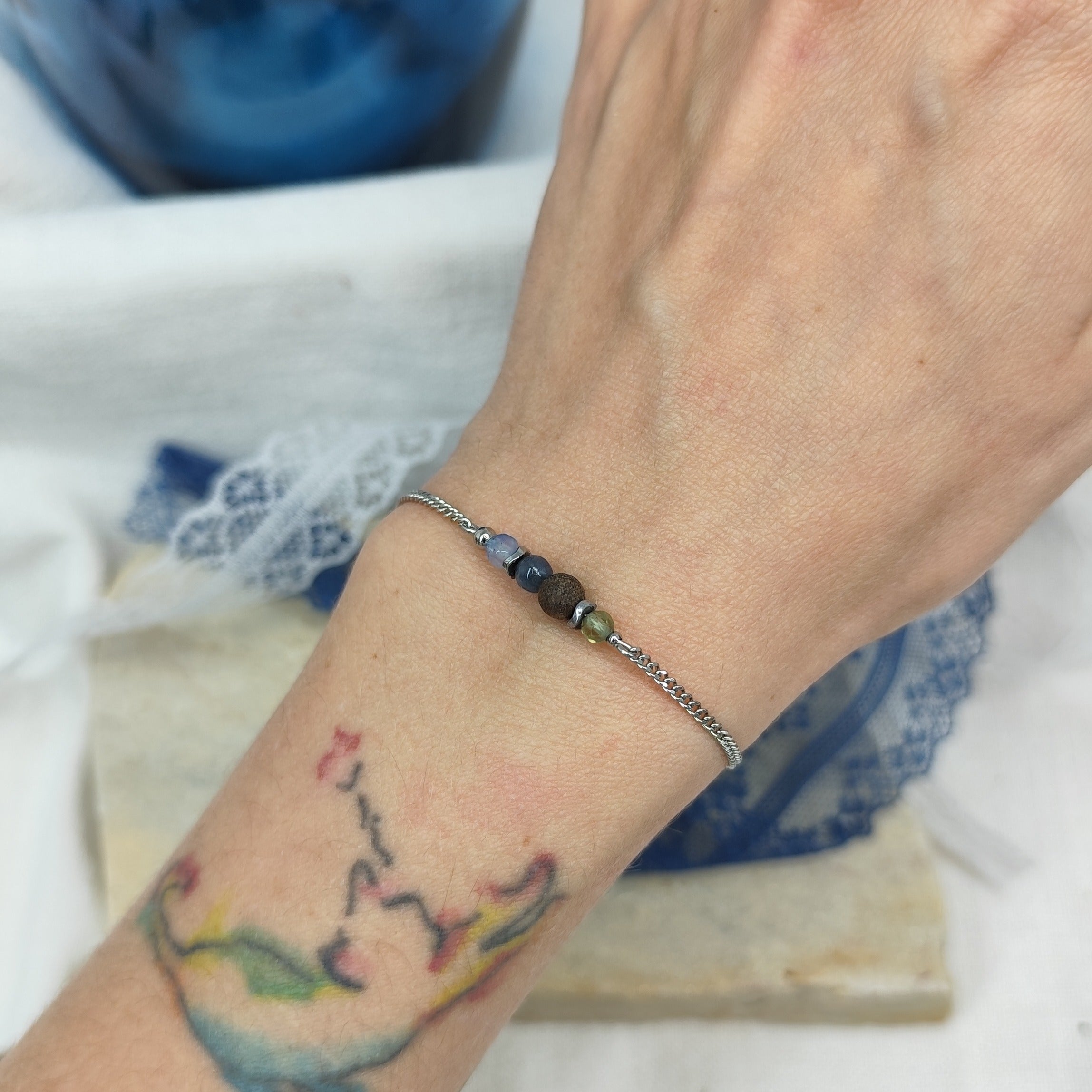 Fein gearbeitetes Armband mit Natursteinen, Hämatit-Zwischenteilen und Nussholzkugel, getragen am Handgelenk