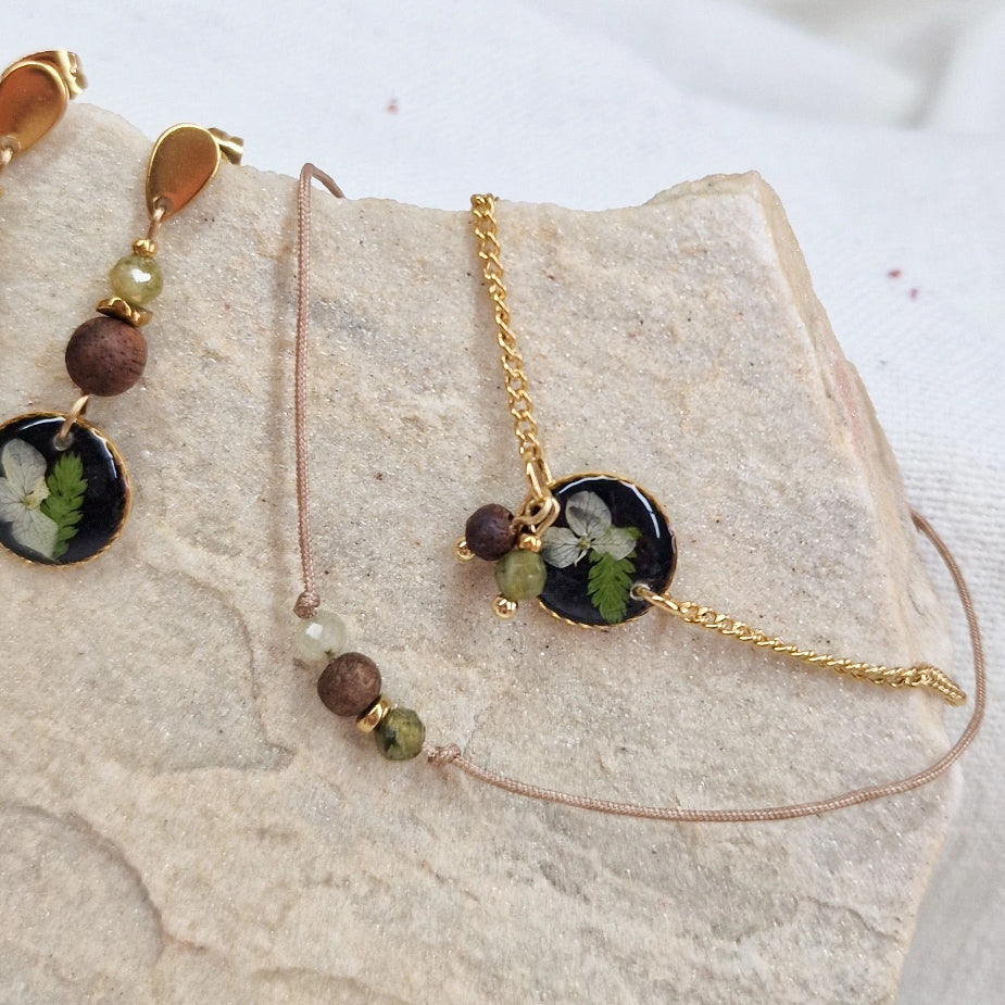 Detailansicht des handgefertigten Holzschmucks ‚Mini Waldlicht‘ mit Resin-Elementen mit echten Blüten und Farnen, Nussholz, Natursteinen und Edelstahldetails