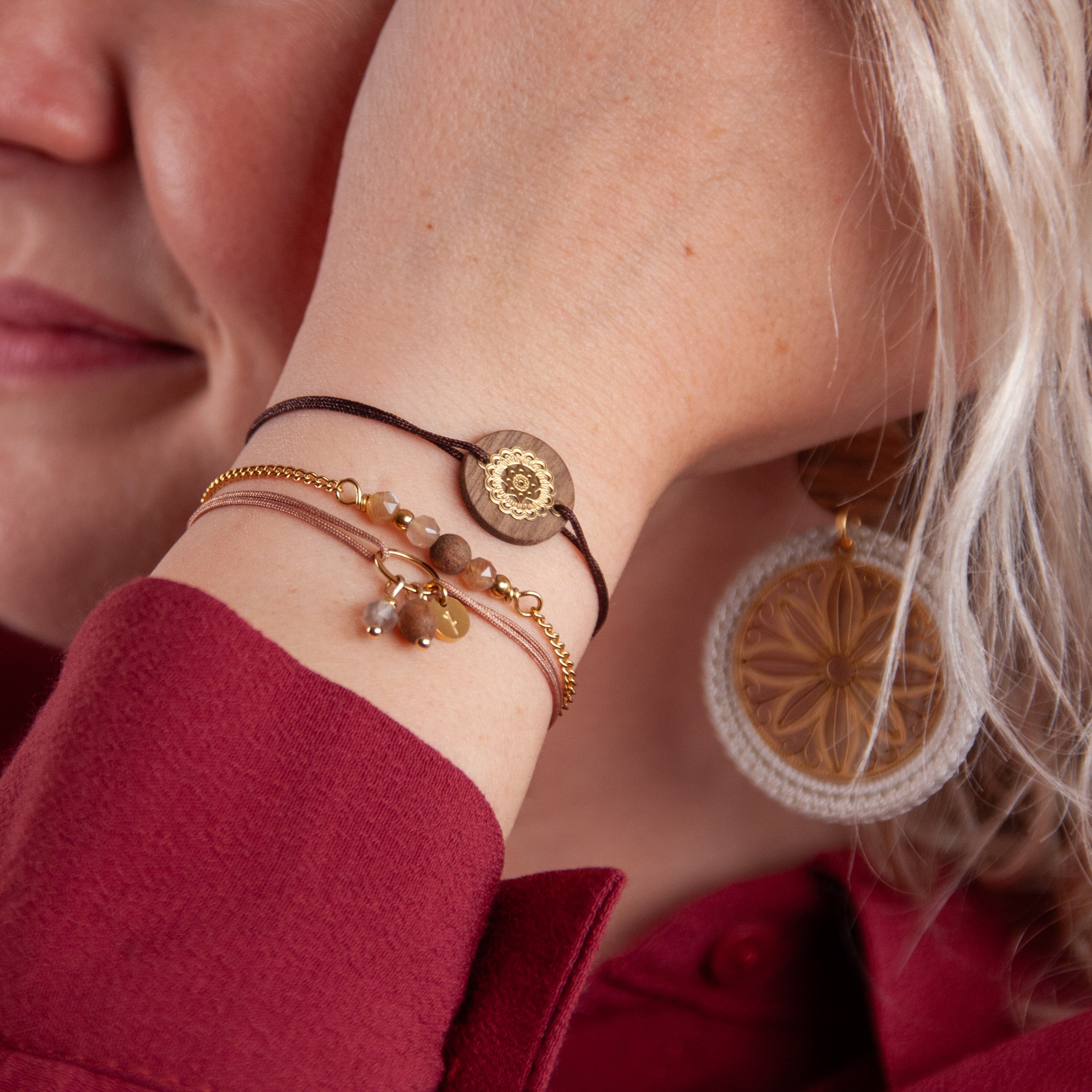 Handgefertigte Armbänder aus Nussholz und Mondstein am Handgelenk getragen, natürliche Hauttöne und weiches Licht.