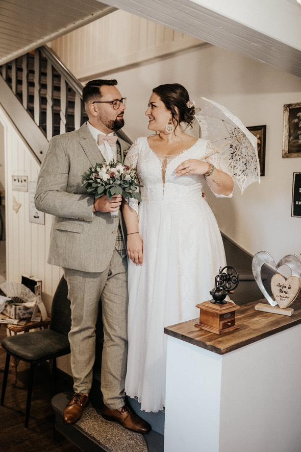 Ein Ehepaar am Tag der Hochzeit in schöner Kleidung sieht sich an und sie trägt einen astwerk Ohrring