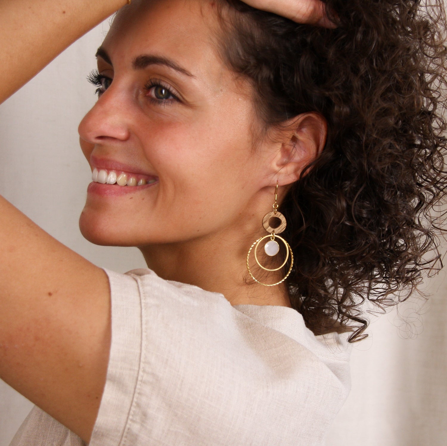 Schmuckset ‚Harmonia‘ mit goldfarbenen Ohrringen aus Holz und Quarz, getragen im Profil