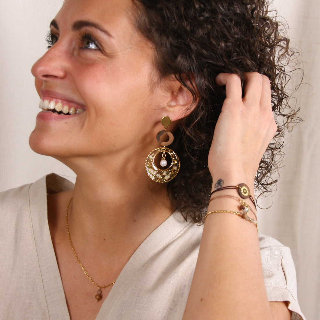 Handgefertigte Ohrringe aus Nussholz und Resin mit Blüten und Perle am Ohr getragen, vergoldeter Edelstahl-Ohrstecker, getragen am Ohr