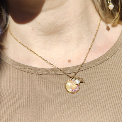 Handgefertigte Halskette aus Nussholz mit Resinelement und Natursteinen, getragen am Hals, feine goldfarbene Edelstahlkette